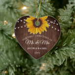 Rustic Sunflower Lights First Christmas Mr. & Mrs. Ceramic Ornament<br><div class="desc">This personalized wedding keepsake design features a pretty painted, watercolor sunflower on a rustic wood background accented with string lights. The collection of coordinating products is available in our shop, zazzle.com/store/doodlelulu. Contact us if you need this design applied to a specific product to create your own unique matching item or...</div>