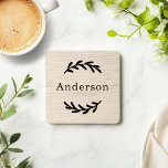 Rustic White Washed Wood Laurel Last Name Monogram Coaster<br><div class="desc">This simply elegant custom monogrammed beverage coaster set features leafy laurel branches that frame a family last name. A beautiful keepsake gift for newlyweds or new homeowners. A natural warm white washed faux wood grain background adds a rustic textured look to the design. Classic black serif text can be modified...</div>