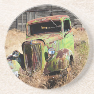 Rusting car in front of abandoned farm coaster