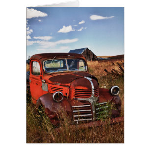 Rusting orange Dodge truck with abandoned farm