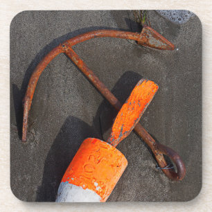 Rusty Anchor And Buoy On A Beach Coaster