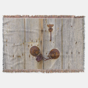 Rusty vintage old iron padlock on a wooden door . throw blanket