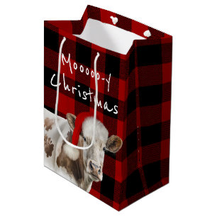 Sac Cadeau Moyen Vache Hereford avec Casquette Père Noël sur Plaid