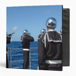 Sailors fire a gun salute during a burial-at-se binder