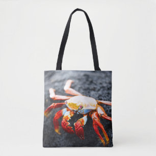Sally lightfoot crab on a black lava rock tote bag