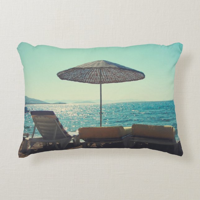 Sandy beach on a sunny afternoon,  with parasols a accent pillow (Front)