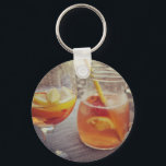 Sangria and Sunshine Keychain<br><div class="desc">This image shows a refreshing glass and pitcher of citrus sangria, perfect for a warm day. The fresh slices of lemon and orange add bright colour and hint of natural sweetness. One glass sits ready to enjoy while sangria is being poured from a small glass pitcher beside it, perfect for...</div>