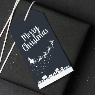 Santa Claus w/ sleigh & reindeers above the houses Gift Tags