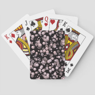 Scatterings of pink and white pearls on black velv playing cards