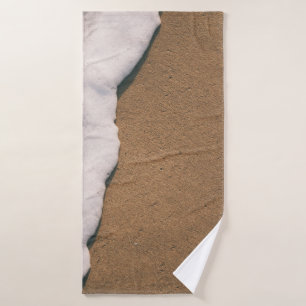 Sea foam on sand bath towel