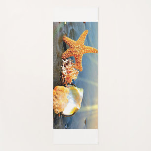Sea shells and starfish on beach yoga mat