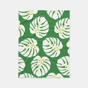 Seamless pattern of white monstera leaves on a dar fleece blanket