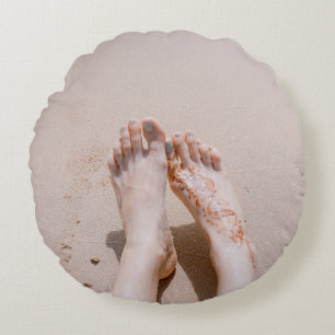 Selective focus photography of feet with tattoo on round pillow