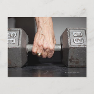 Senior woman lifting weights postcard