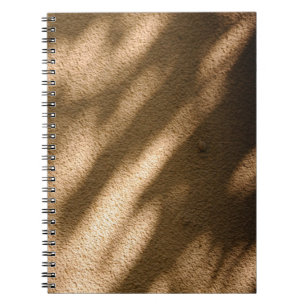 Shadow on brown carpeted floor notebook