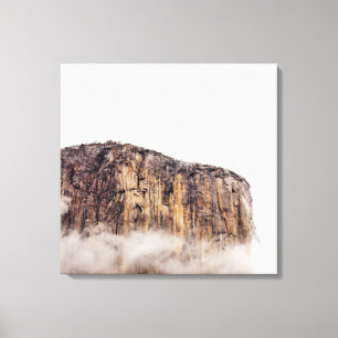 Sheer cliff rising above clouds canvas print