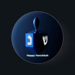Shiny Blue Dreidel 2 Inch Round Button<br><div class="desc">A modernistic,  metallic blue dreidel against a dark,  night-like background.  Two of the Hebrew letters found on a dreidel,  nun and shin,  glow brightly.  Text reading "Happy Hanukkah" also appears in glowing blue and white.</div>