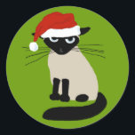 Siamese Santa Clause - Funny Christmas Cat Classic Round Sticker<br><div class="desc">Grouchy Siamese Cat Holiday Stickers. Funny cat wearing a Santa Clause hat. This annoyed kitty says Bah Humbug to wearing a ridiculous hat. These fun stickers are perfect for sealing the back of holiday envelopes. Visit Jenn’s Doodle World for more funny cat lover's products and cool gifts featuring this humourous...</div>