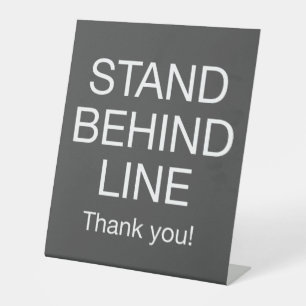Signe De Table Se tenir derrière la ligne