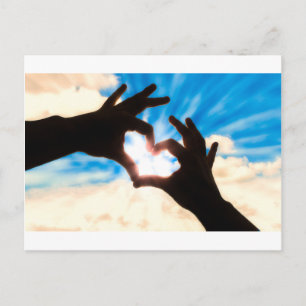 Silhouette hands in heart shape and blue sky postcard