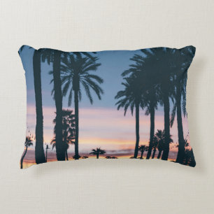 Silhouette of houses beside palm trees and pathway accent pillow