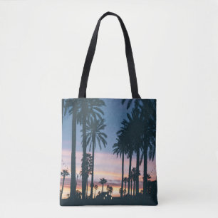 Silhouette of houses beside palm trees and pathway tote bag