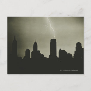 Silhouettes of skyscrapers and lightning in sky postcard