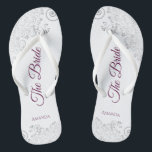 Silver Lace Cassis Purple The Bride White Wedding Flip Flops<br><div class="desc">Dance the night away with these beautiful wedding flip flops. Designed for the bride, they feature a simple yet elegant design with cassis purple, magenta, or berry coloured script lettering on a white background and fancy silver grey lace curls and swirls. Beautiful way to stay fancy and appropriate while giving...</div>