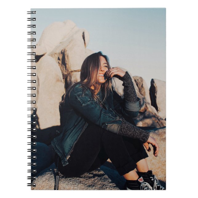 Sitting and smiling woman wearing black pants notebook (Front)