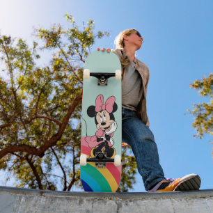 Skateboard Minnie Assis sur un arc-en-ciel