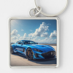 Sleek Blue Sports Car Under a Vibrant Cloudy Sky Keychain