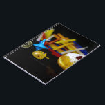 SlipperyJoe Hanukkah symbolic still life holiday e Notebook<br><div class="desc">SlipperyJoe Hanukkah symbolic still life holiday essence vibrant meaningful objects colourful slender pile menorah candles artistic red blue yellow and white sufganiyah doughnut classic jelly-filled commemorate miracle of the oil dreidels metallic gold glossy blue Hebrew great miracle happened there metallic pewter star of David medallion light resilience community themes spiritual...</div>