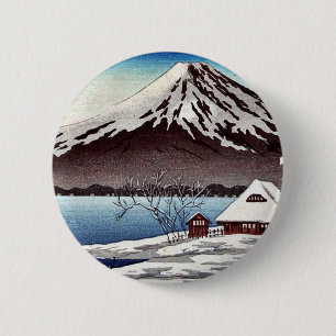 Small snow covered building on the coast 2 inch round button