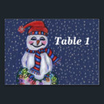 Smiling Snowman Holding String of Christmas Lights Table Number<br><div class="desc">This table number card for your parties or events has a smiling snowman with a carrot nose wearing a winter blue and red hat and scarf holding a lit string of colourful Christmas lights on a dark blue background with falling snow.  Customize your table number with the template.</div>