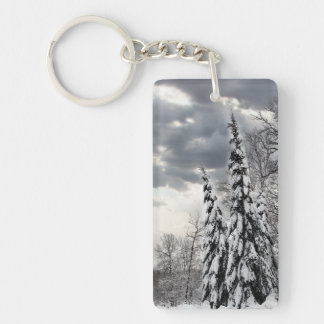 Snow-Covered Evergreen Trees Under Dramatic Winter Keychain