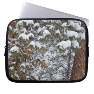 Snow fills the boughs of ponderosa pine trees laptop sleeve