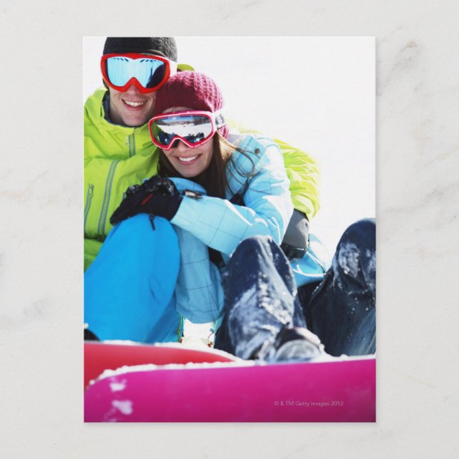 Snowboarder couple sitting on snow postcard (Front)
