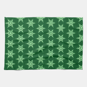 Snowflakes, pale green crystals on dark green kitchen towel