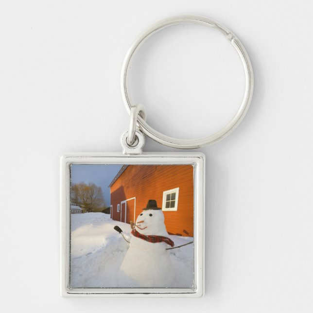 Snowman in front of red barn in Columbia Falls Keychain (Front)