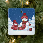 Snowman Knitting Christmas Scarf Ceramic Ornament<br><div class="desc">Cartoon illustration of two adorable snowmen dressed in knitted hats and scarves. The big snowman is knitting an oversized scarf for the little one. The scarf is already wrapped several times around the cute little snowman.</div>