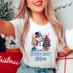 Snowman Vibes Women's T-Shirt<br><div class="desc">Snow day t-shirt, cute winter shirt, festive snowman tee, women’s holiday wear, cozy winter vibes shirt. Get into the winter spirit with this cheerful "Snow Day Vibes" tee! Featuring a cute snowman with a pink scarf and a festive tree, it's the perfect shirt for those cozy, snowy days. 𝐓𝐡𝐞 ☛​̳"​̳𝙀​̳𝘿​̳𝙄​̳𝙏​̳...</div>