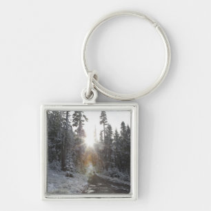 Snowy dirt road going into the sun keychain