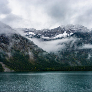 Snowy mountains in the fog at Plansee lake  