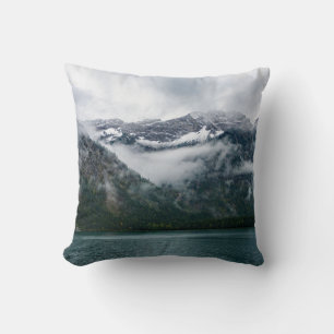 Snowy mountains in the fog at Plansee lake Throw Pillow
