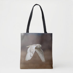 Snowy owl in flight tote bag