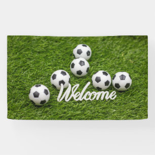 Soccer ball with Welcome sign on green grass