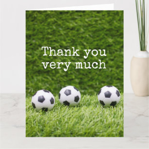 Soccer ball with word Thank you on green grass Card