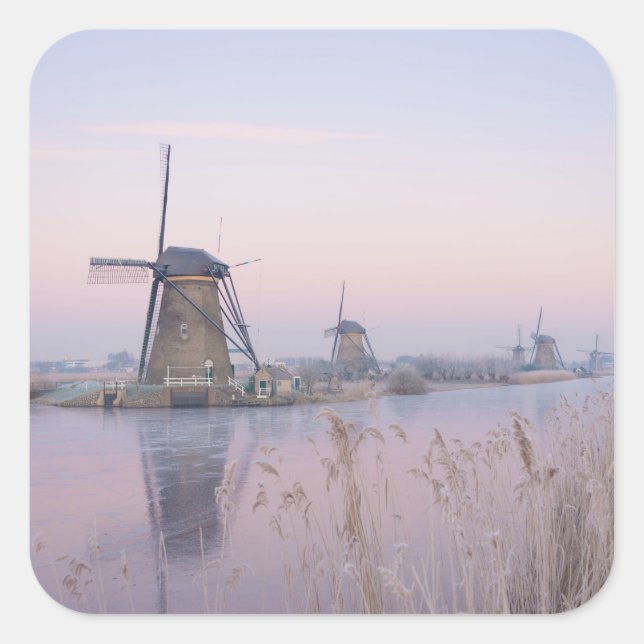 Soft sunrise light in winter over windmills square sticker (Front)