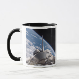 Space Shuttle Discovery backdropped by Earth Mug