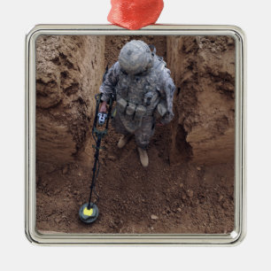 Specialist searches for a weapons cache metal ornament